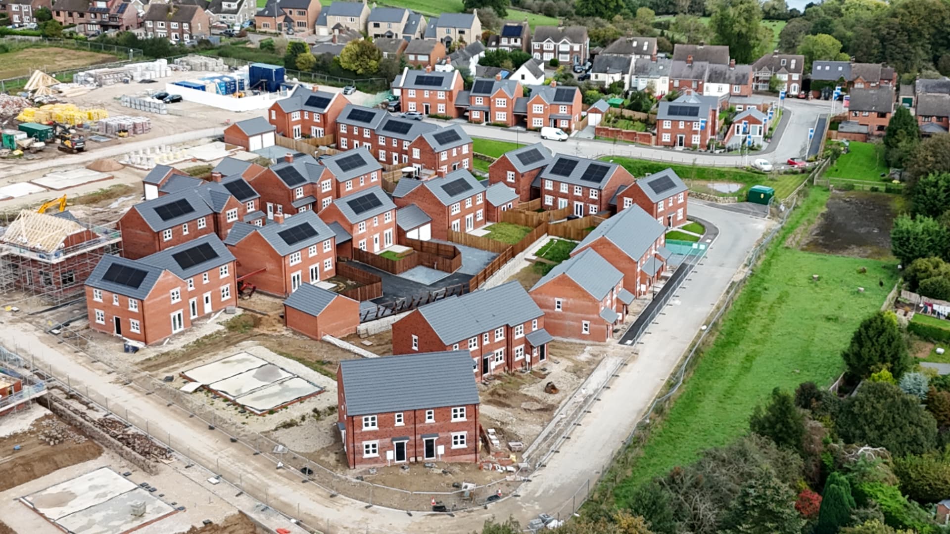 Completed brick homes with slate roofs and solar panels on a new estate